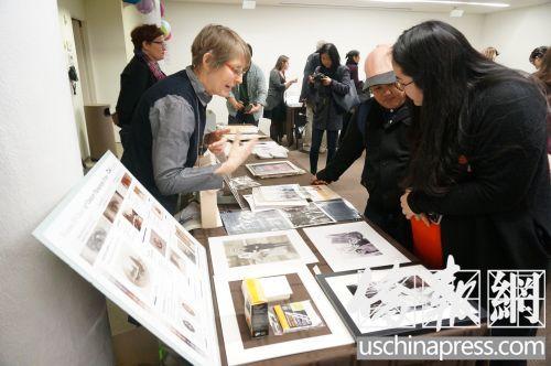 中国侨网纽约市档案局工作人员向参与民众介绍照片保存。（美国《侨报》/陈辰 摄）