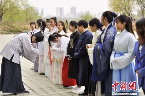 中国侨网4月9日，兰州黄河岸边，一群青年身着汉服，学习讨论有关汉服以及千年传统文化习俗的相关知识。　徐杉　摄