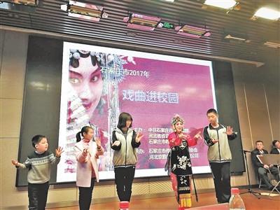 中国侨网石家庄市戏曲文化进校园活动启动仪式上，戏曲演员教学生学习戏曲动作。（彭尧 摄）