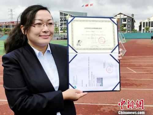中国侨网刘彦麟展示法国国际文化艺术交流协会理事聘书及法国鲁贝市政府授予的其作品《红三》收藏荣誉证书。(杨云 摄)
