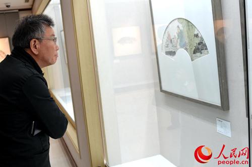 中国侨网韩国民众欣赏画扇面作品。(人民网记者 周轩 摄)