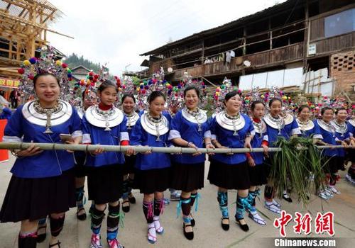 中国侨网民众身着节日盛装在拦路迎客。　吴练勋　摄