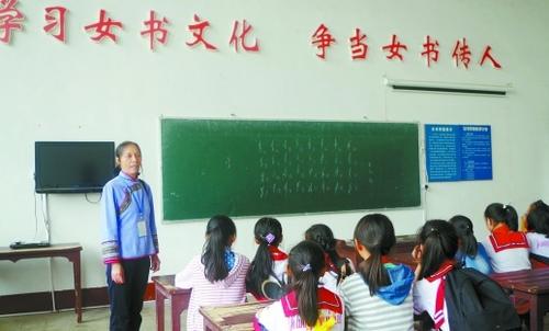 中国侨网2016年10月24日，江永女书生态博物馆，女书传人胡美月向小学生传授女书。（任泽旺 摄）