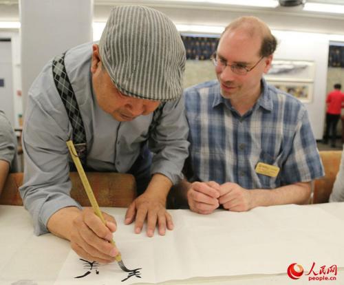 中国侨网5月3日，刘述伶在美国西肯塔基大学孔子学院向美国师生教授毛笔字。（人民网 韩莎莎摄）