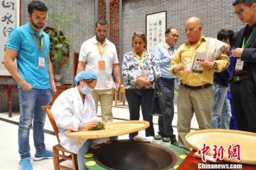中国侨网现场展示土家传统手工炒茶技艺。　钟欣　摄