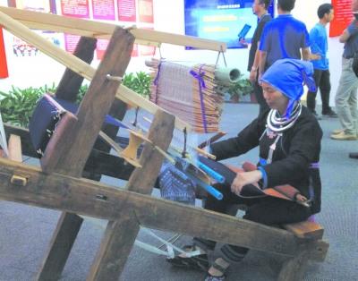 中国侨网国家级非遗传人粟田梅现场展示侗锦织造技艺。