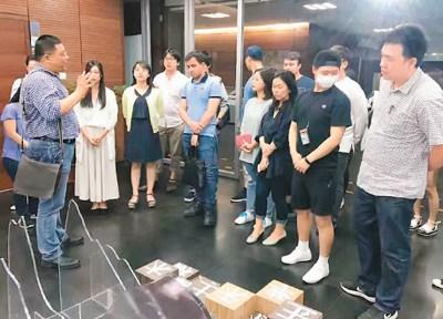 中国侨网孟德宏（左一）在展览现场为北京外国语大学来自菲律宾等国的留学生上了一堂中国语言文化课。