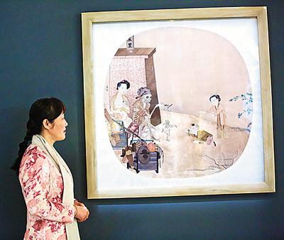 中国侨网第57届威尼斯国际艺术双年展中国馆，艺术家姚惠芬与一幅刺绣作品合影。（新华社记者 金宇 摄）