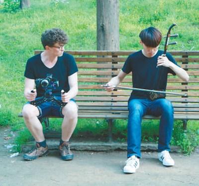 中国侨网塞尔维亚青年学生阿克斯（左）在拍摄二胡演奏。  　　陈柔妍摄