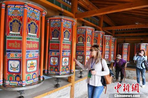 中国侨网图为国外旅行商在拉卜楞寺体验转经轮。　杨艳敏　摄