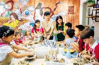 中国侨网曲俊蒙和妻子郑婷在三亚为学生们上陶瓷微雕捏塑课。 海南日报记者 武威 摄