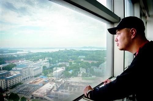 中国侨网图为陈强在办公室远眺武汉，眺望他和弟弟妹妹在武汉的美好未来。