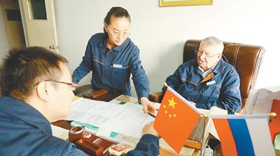 中国侨网西特里维(右一)正为中方员工讲解工艺流程。资料图片