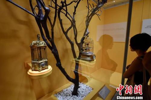 中国侨网图为展馆内展出的法国19世纪木制金漆圆鸟音笼表。　吕明　摄