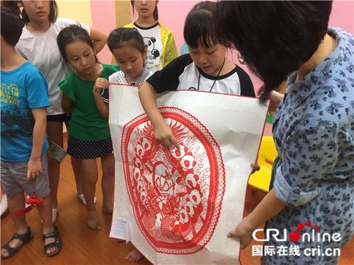 中国侨网熊猫小记者向新加坡北京语文学校老师赠送中国传统剪纸