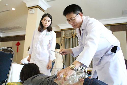 中国侨网义诊活动现场，一名泰国本土执业中医师正在为病患进行拔罐治疗。 图片由泰国东方大学孔子学院提供