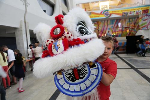 中国侨网6月22日，在白俄罗斯首都明斯克，一个孩子手举舞狮道具 魏忠杰摄