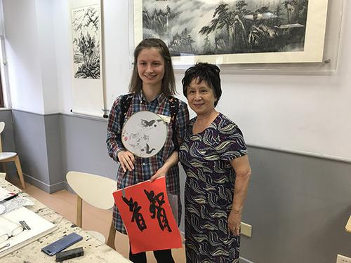 中国侨网白俄罗斯学者Katsiaryna Malyshava（智音）在书画活动室与当地居民合影
