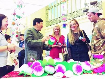 中国侨网顾业亮向外国观众介绍秦淮花灯的制作方法。本报记者 朱凯摄