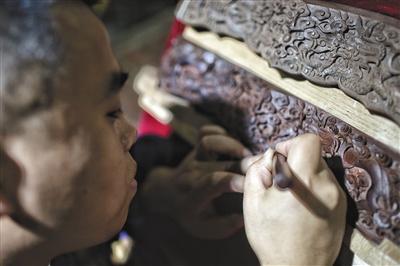中国侨网昨日（9月11日），第十二届北京文博会开幕，一位参展的手工艺人正在修复一件木雕。新京报记者 彭子洋 摄