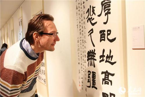 中国侨网俄罗斯民众认真欣赏中国书法家的汉字作品。(人民网记者 华迪 摄)