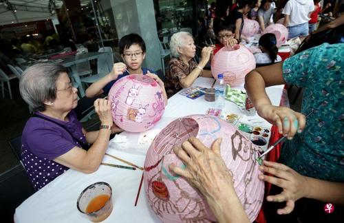 中国侨网图为潘俊杰（左二）与新加坡唐人街乐龄中心的年长者一同彩绘灯笼。（新加坡《联合早报》/陈渊庄 摄）