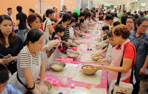 中国侨网数百人集体放下手机，搓起面团动手做月饼，重温中秋团圆之意。（马来西亚《星洲日报》）