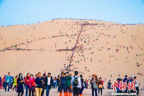 中国侨网10月3日，敦煌鸣沙山上人流如织。　王斌银　摄