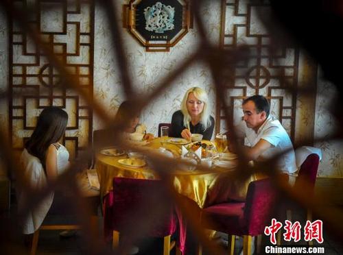 中国侨网外国食客在享用中国美食。（中新网记者 刘新 摄）