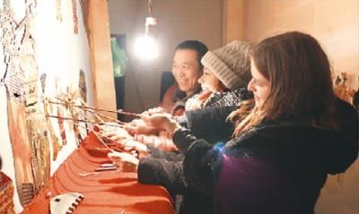 中国侨网伊莉和白皓月在学皮影戏