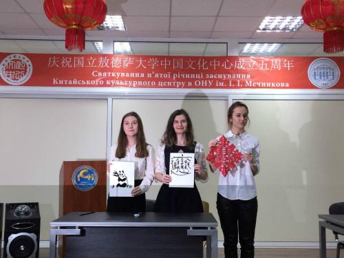 中国侨网敖德萨国立大学学生展示剪纸和书法作品。
