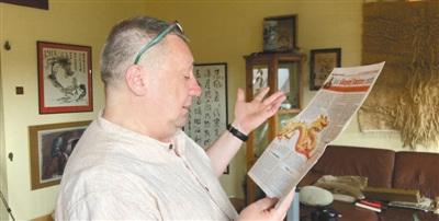 中国侨网皮特向本报记者介绍他在当地报纸上刊发的一篇文章。(本报记者 暨佩娟 摄)