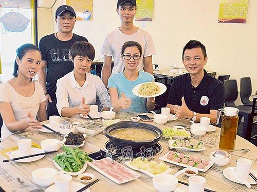 中国侨网钟方香(坐者右2)向市民推介猪肚鸡火锅。(马来西亚《中国报》/赵诗绮 摄)