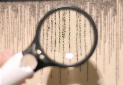 中国侨网王芝文的陶瓷微书作品需用放大镜来看。