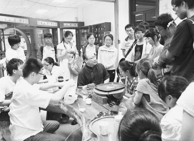 中国侨网高嘉骏在福建中医药大学图书馆，利用做讲座的休息时间，回答学生的问题。（资料图片）