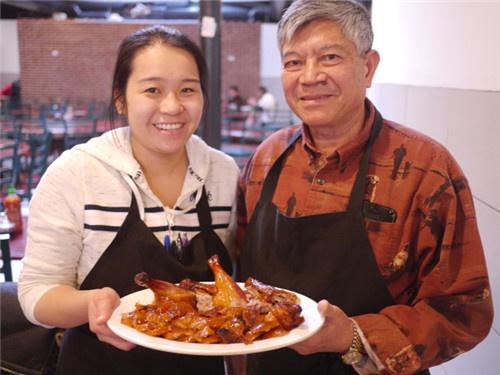 中国侨网毕业于专业餐饮学院的小女儿郑文彩(左)，在父亲郑兆章(右)指导下，片鸭功力了得。(美国《世界日报》/黄惠玲 摄)