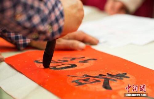 中国侨网资料图:2018年2月3日,北京一便民网站组织各社区的书法爱好者免费为市民书写春联,以传统形式增添节日喜庆。中新社记者 侯宇 摄