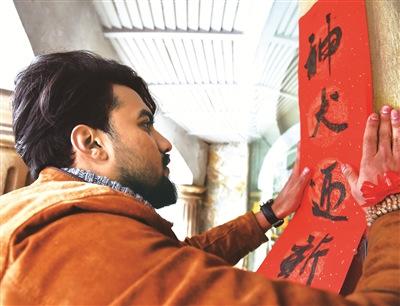 中国侨网老外贴春联。 （严龙　张昊桦 摄）