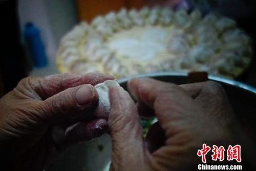 中国侨网资料图：山东省蓬莱市一户家庭为除夕年夜饭包饺子。廖攀 摄