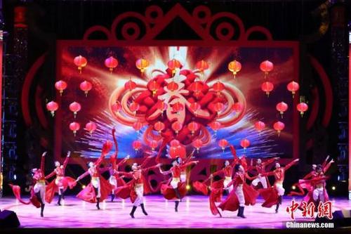 中国侨网资料图：2月4日晚，2018年“文化中国·四海同春”在香港举行。晚会以“扬帆再启航”为主题，主舞台以红色的“牡丹花”为背景，衬托新春佳节的喜庆氛围。图为开场舞表演。中新社记者 谢光磊 摄