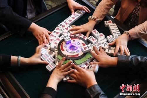 中国侨网资料图,巴蜀很多餐馆都提供麻将机,聚餐过后大家不打上几盘麻将是不愿离开的。在达州一餐馆内正在打麻将的人们。中新社发 熊然 摄