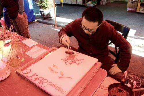 中国侨网“糖画”师傅现场作画,一分钟就画好了。(美国《世界日报》/李晗 摄影)