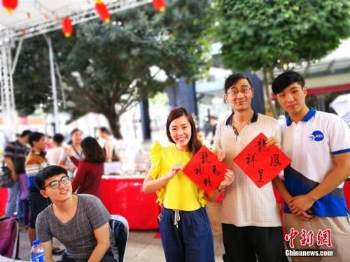 中国侨网资料图:2月18日,菲律宾市政府与菲中电视台合作在BGC市民活动中心展开中国新年推广中华文化活动。图为参与活动的菲律宾雅典耀大学孔子学院志愿者写挥春为过往游客、市民送祝福。中新社记者 关向东 摄