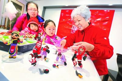 中国侨网昨天（3月11日），文化志愿者李文生老人向小朋友们传授面塑技艺，并展示自己精心制作的冬奥会面塑作品。（本报记者 方非摄）
