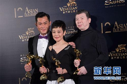 中国侨网3月17日，古天乐、张艾嘉和冯小刚（从左至右）在后台展示奖杯。 新华社记者 张金加 摄