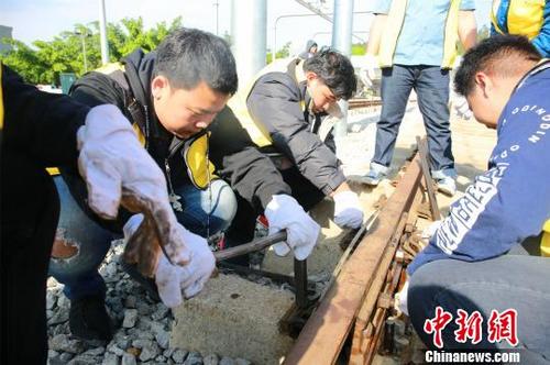 中国侨网泰国留学生在扭螺丝，进行钢轨接头拆装。　朱柳融　摄
