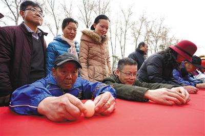 中国侨网3月21日,第十二届“春分·朝阳”民俗文化节亮相日坛公园,游客在现场比赛竖鸡蛋。 新京报记者 王飞 摄