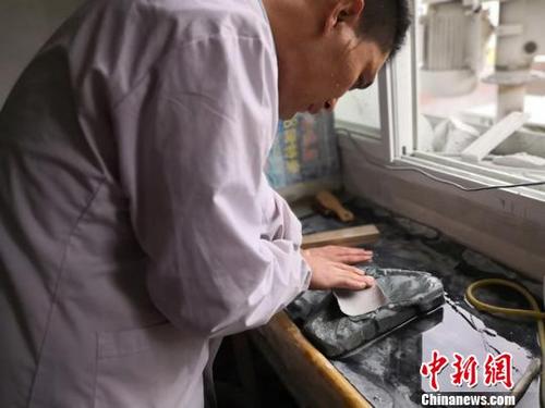 中国侨网近日，在兰州大沙坪上川村，甘肃洮砚艺人黄炳强在自己的工作室里埋头雕刻。　杨娜　摄