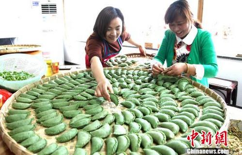 中国侨网4月2日，“徽姑娘”王海英（左一）正在教游客制作“清明饺”。　吴建平　摄