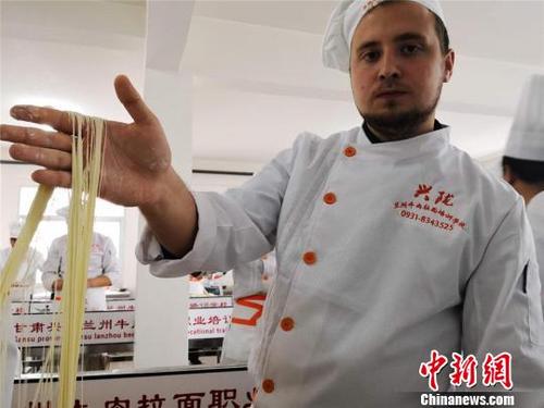 中国侨网图为来自哈萨克斯坦的留学生赤龙展示拉出的“毛细”面型。毛细是牛肉面中最细的一道面食，成型后“细如发丝”。　史静静　摄
